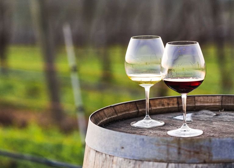 Two wine glasses, one with red and one with white wine