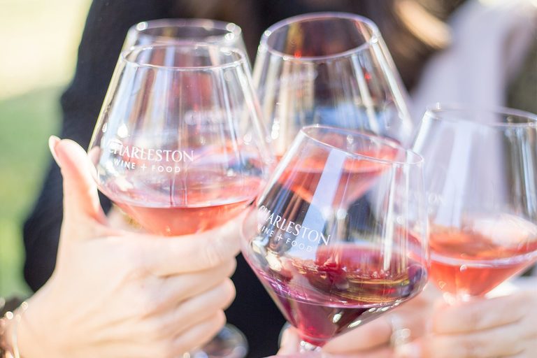 People clink "cheers" with wine glasses