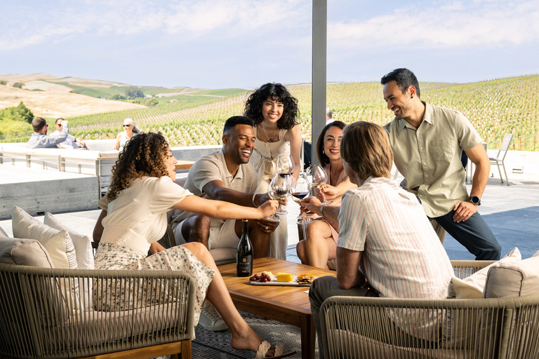 Friends toast glasses in a winery tasting room