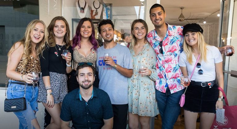 8 friends post for a photo at a wine festival
