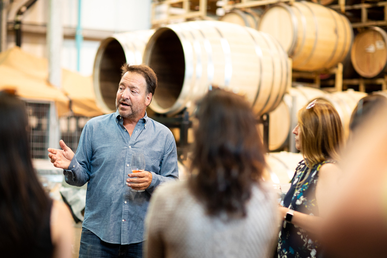 A winemaker talks to a group of guests