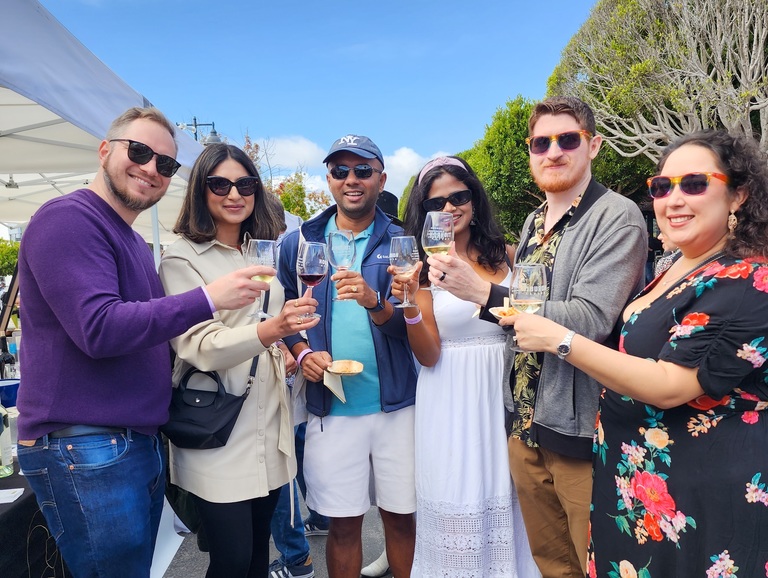 A couple at a wine festival hold a bottle of wine