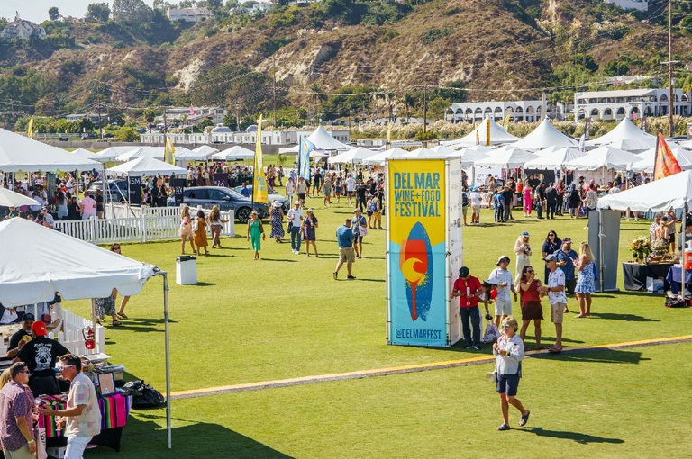 A wine festival with white tents in a large green field