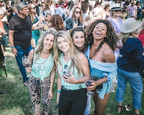 A group of 4 women are happy at a wine festival