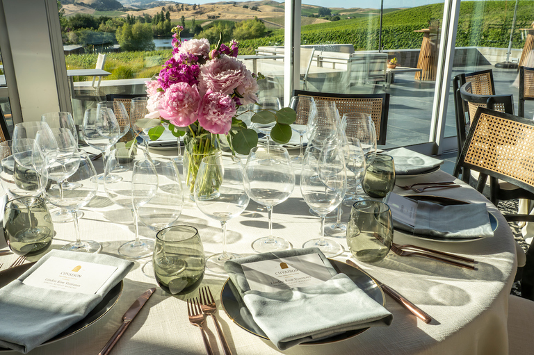 A formal table setting in a winery tasting room at sunset