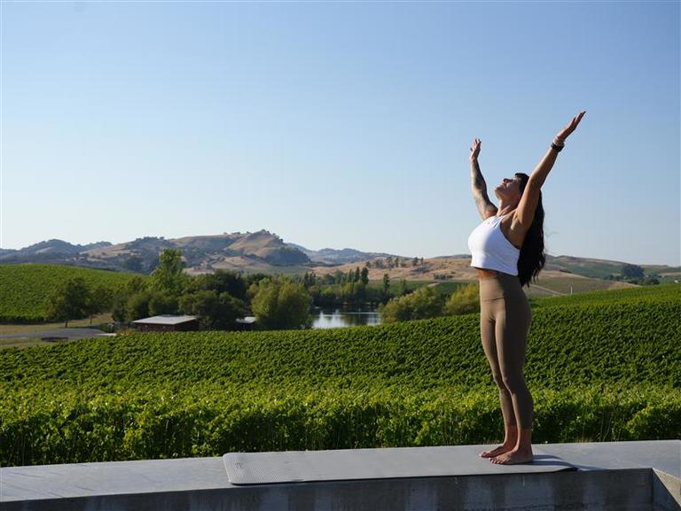A fitness instructor stretches at a winery
