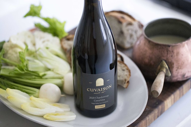 A bottle of Cuvaison Chardonnay and fondue with olive bread and vegetables