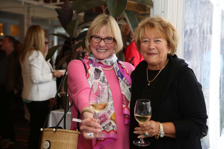 Two happy ladies holding wine glasses